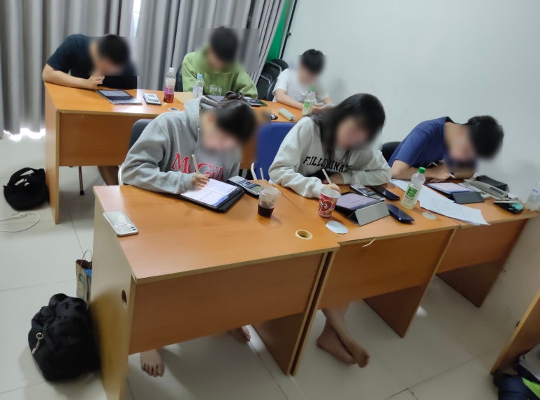 Students concentrating on IB Chemistry practice questions in class